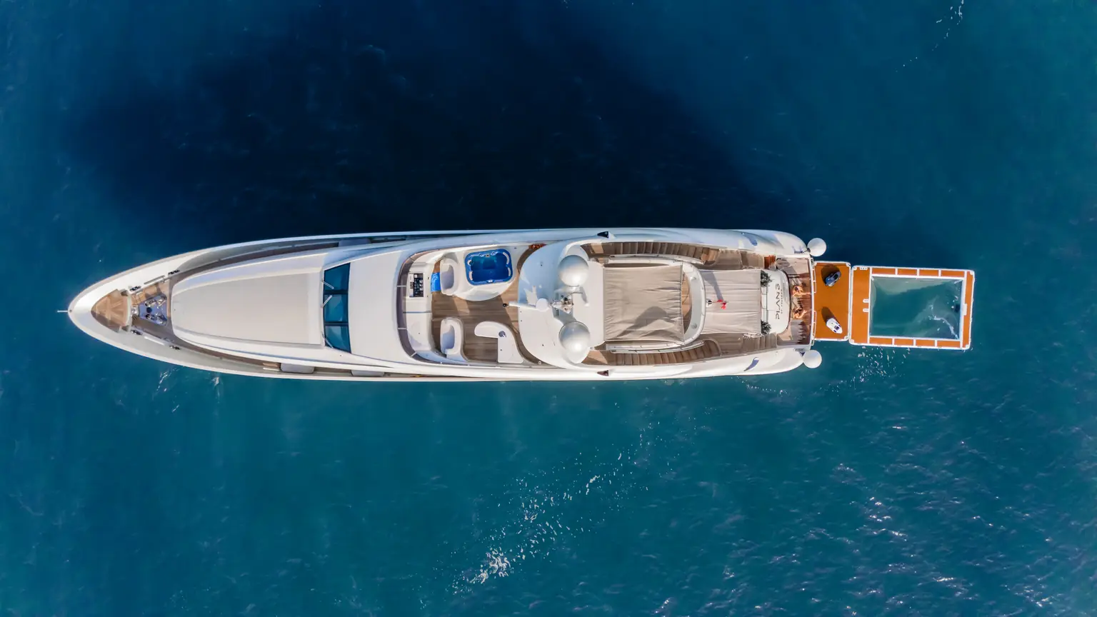 Overhead aerial view of Plan B of Freedom showing her sun deck, tender bay and the floating sea pool off her stern