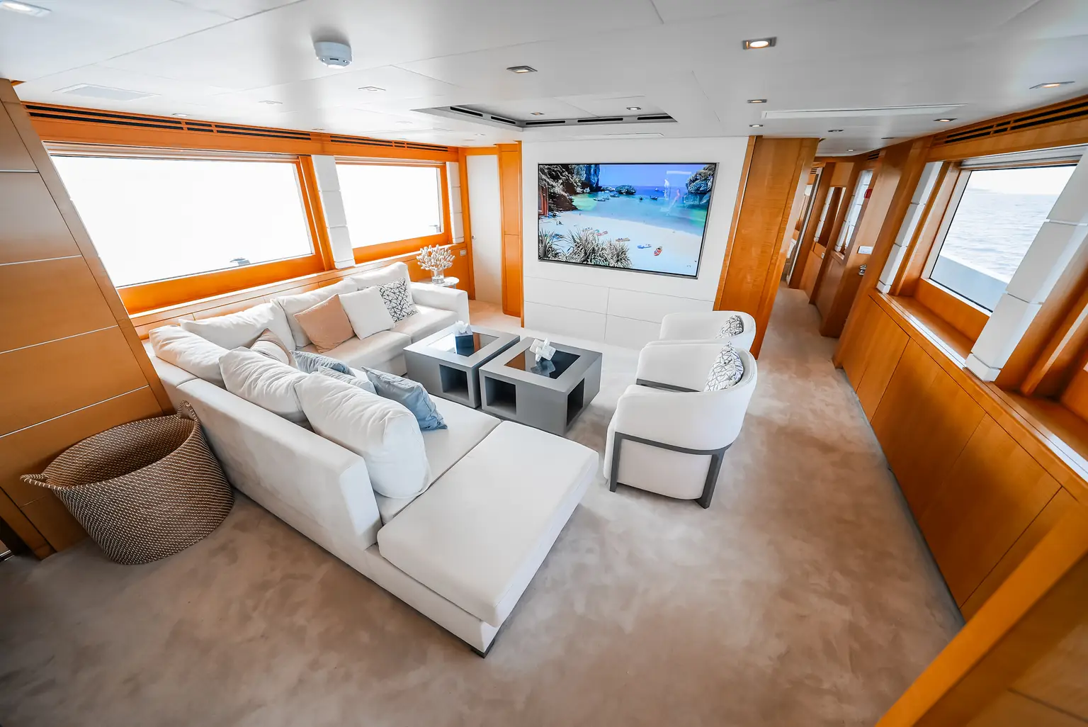 Main salon with pale seating, panoramic windows and polished cherry joinery