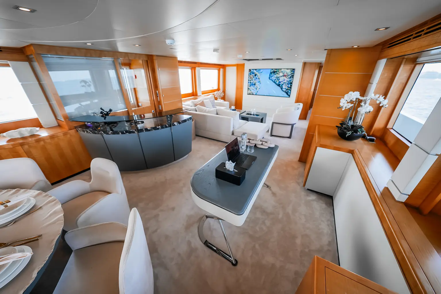 Salon looking aft towards the bar, with armchairs and a low table
