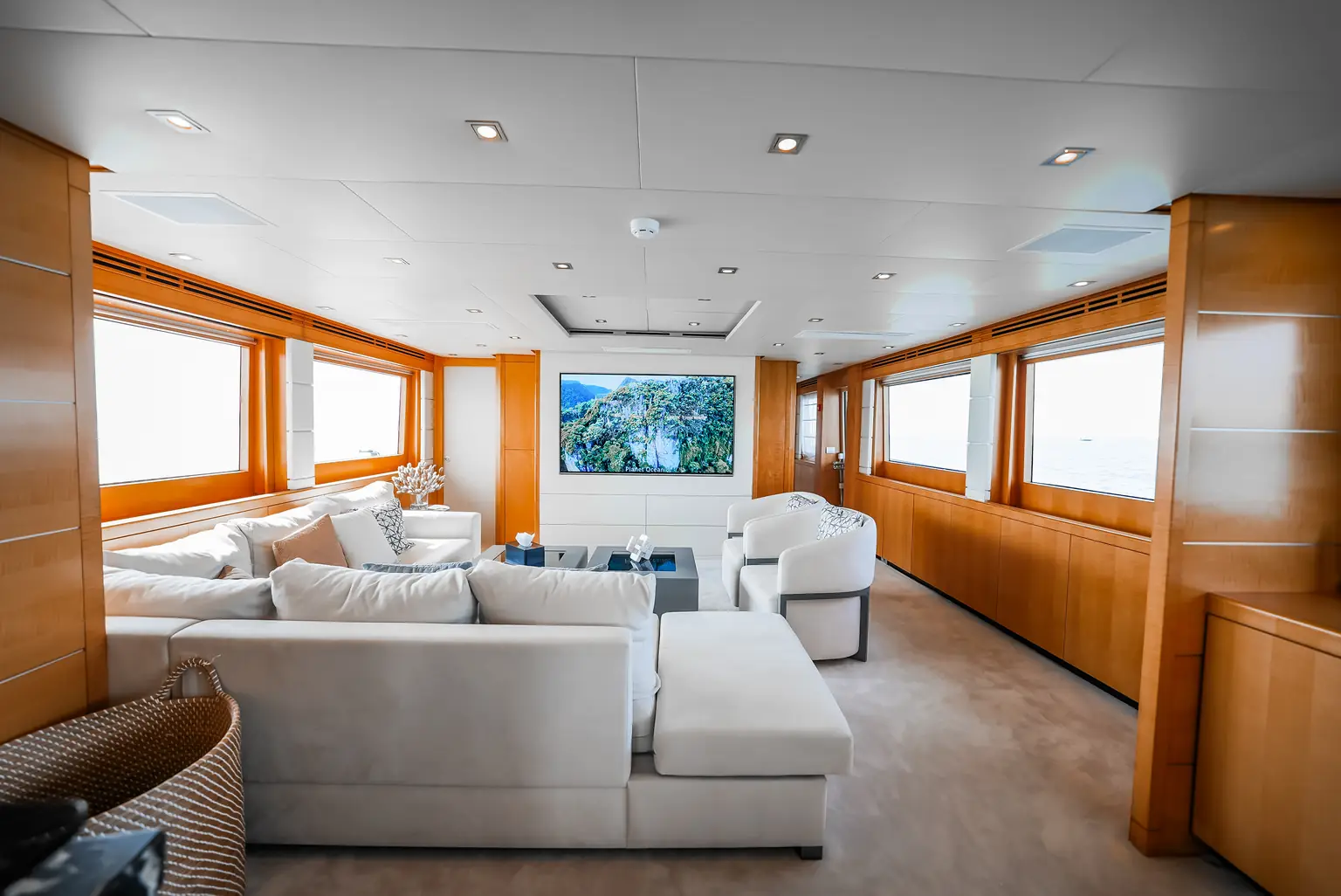 Full-beam salon lounge with sofas running the width of the yacht